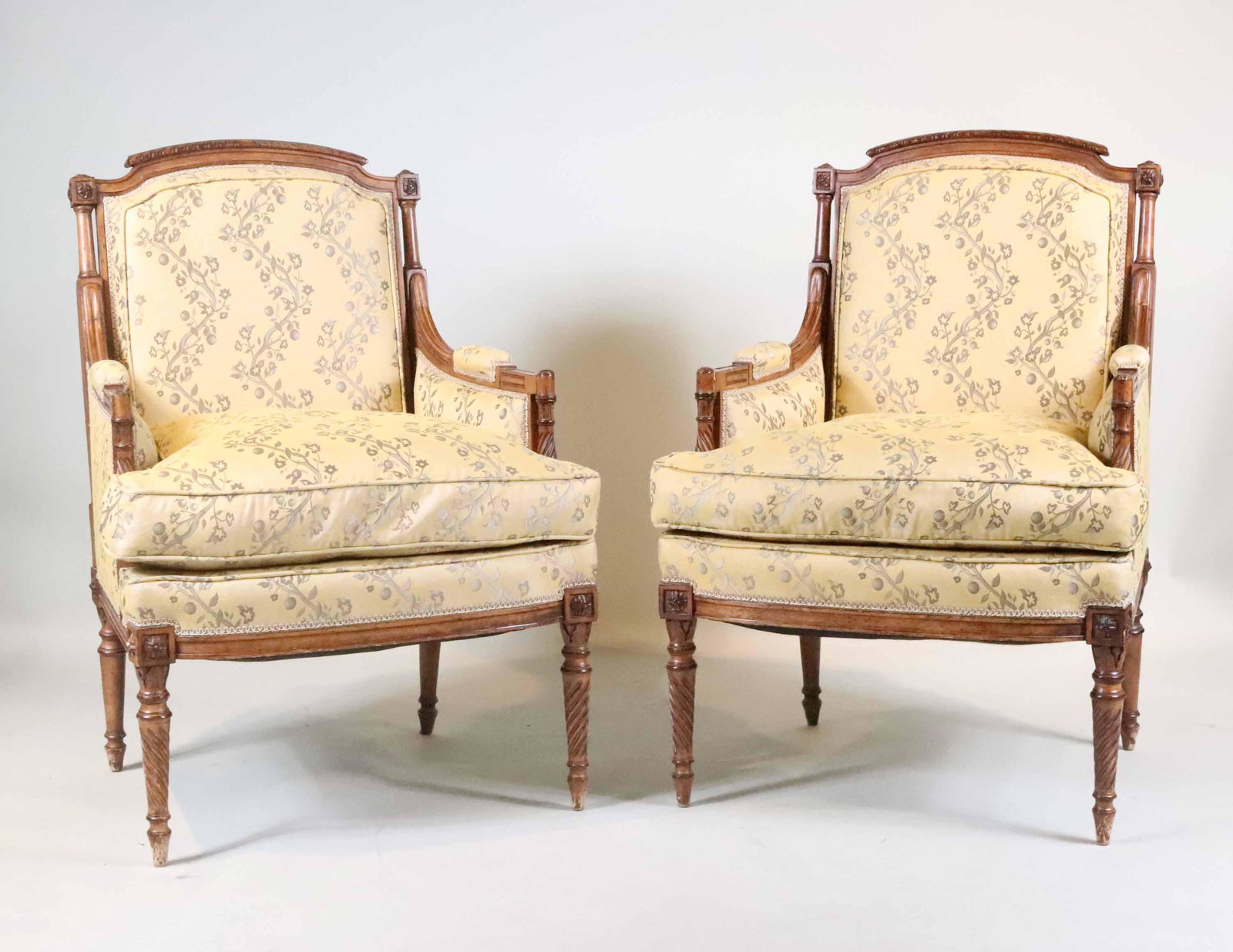 Pair of Neoclassical Style Beechwood Bergeres: Continental Taste, 20th C. with yellow upholstery and Antiqued finish on wood. 40"h x 27"w x 28"d