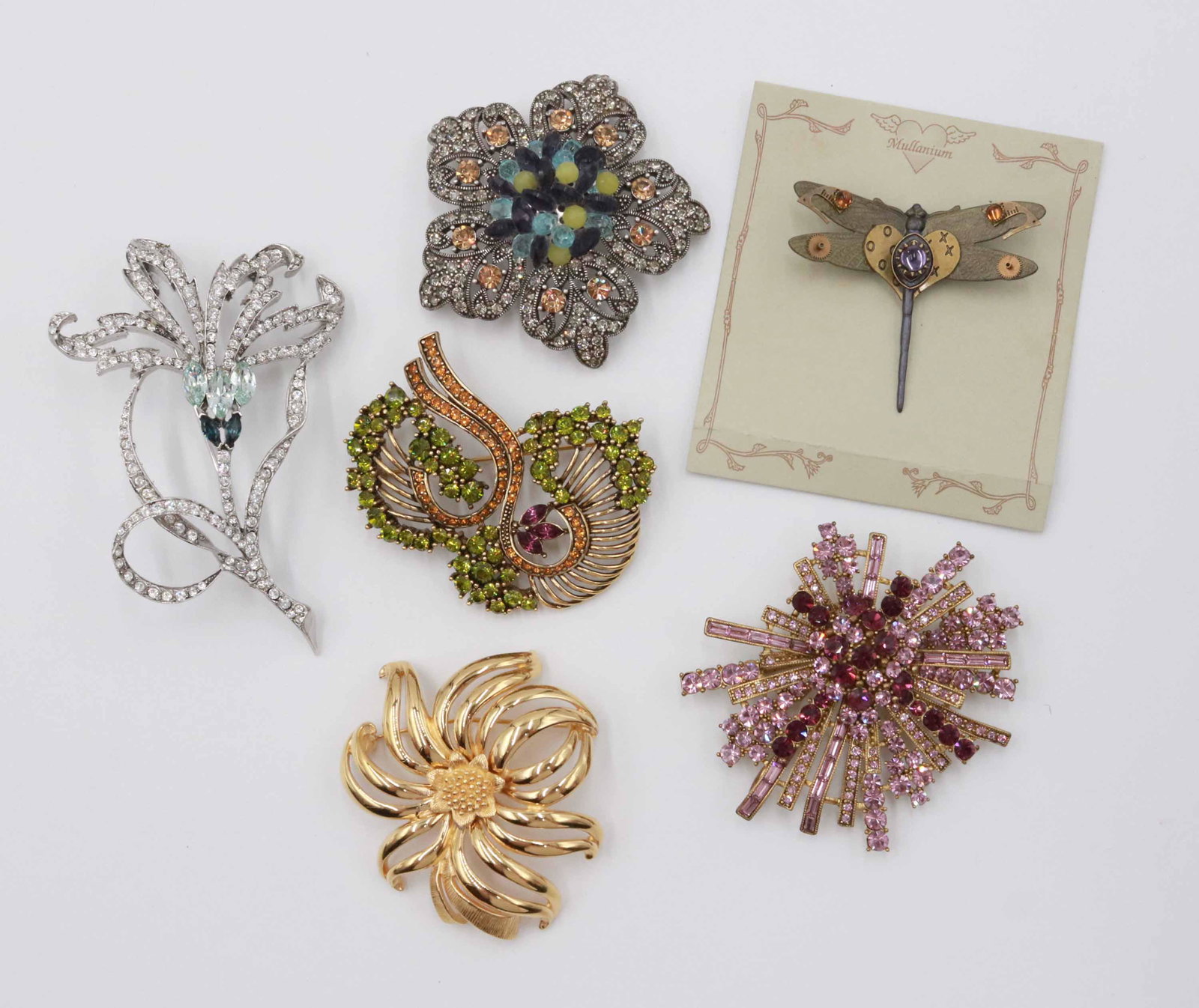 Monet Swirl Form Flower Brooch: Together with an unmarked purple spray brooch, an unmarked green swirl brooch, an unmarked blue floral brooch, a Lee Angel orchid brooch and a "Mullanium" dragon fly pin.