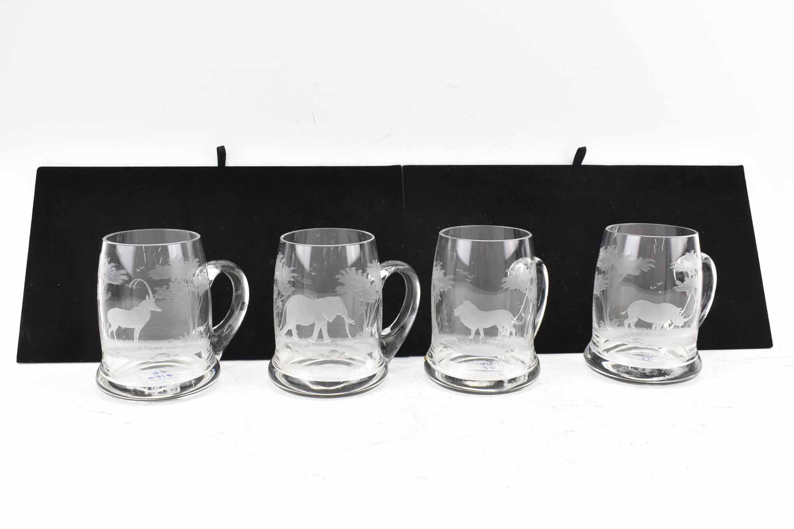 4 Roland Ward Crystal Big Game Mugs: 4 Roland Ward/Queen's Lace Crystal Big Game Mugs including Elephant, Lion, Rhino and Antelope; used condition, wear/worn, chip to rim on elephant mug, measures 5" high