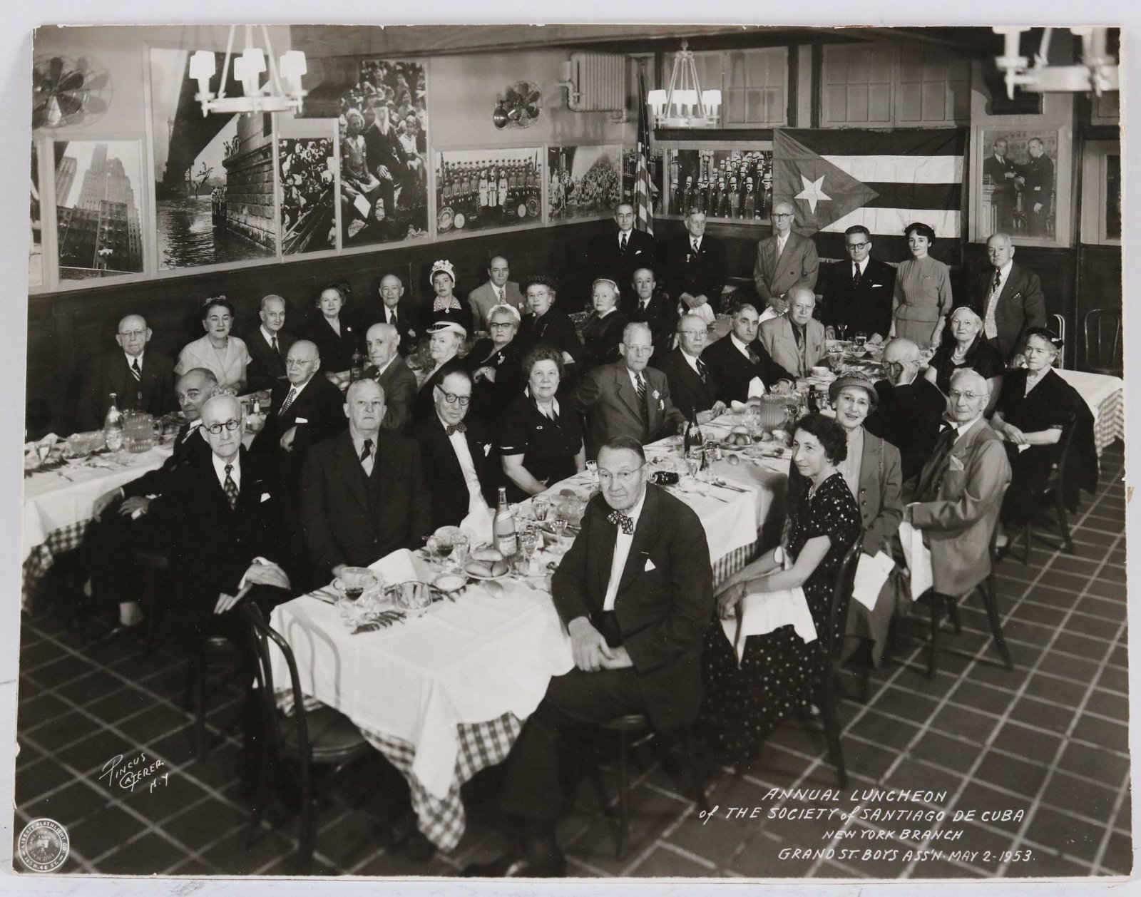 Black & White Photo, Society of Santiago de Cuba: Depicting the Annual Luncheon of the Society of Santiago de Cuba, New York Branch, Grand St. Boys Ass'N, May 2, 1953, signed l.l. "Pincus Caterer, NY." stamped by Liberty Flashlight Co., 165 W. 48 St.