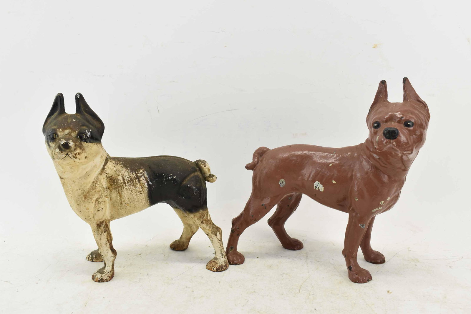 2 Cast Iron Standing Boston Terrier Dog Doorstops: 2 Cast Iron Standing Boston Terrier Dog Doorstop, one painted black & white, the other painted brown; used condition, wear/worn, paint loss, chips, largest measures 10 1/2" high x 9" long x 5 1/2" wid