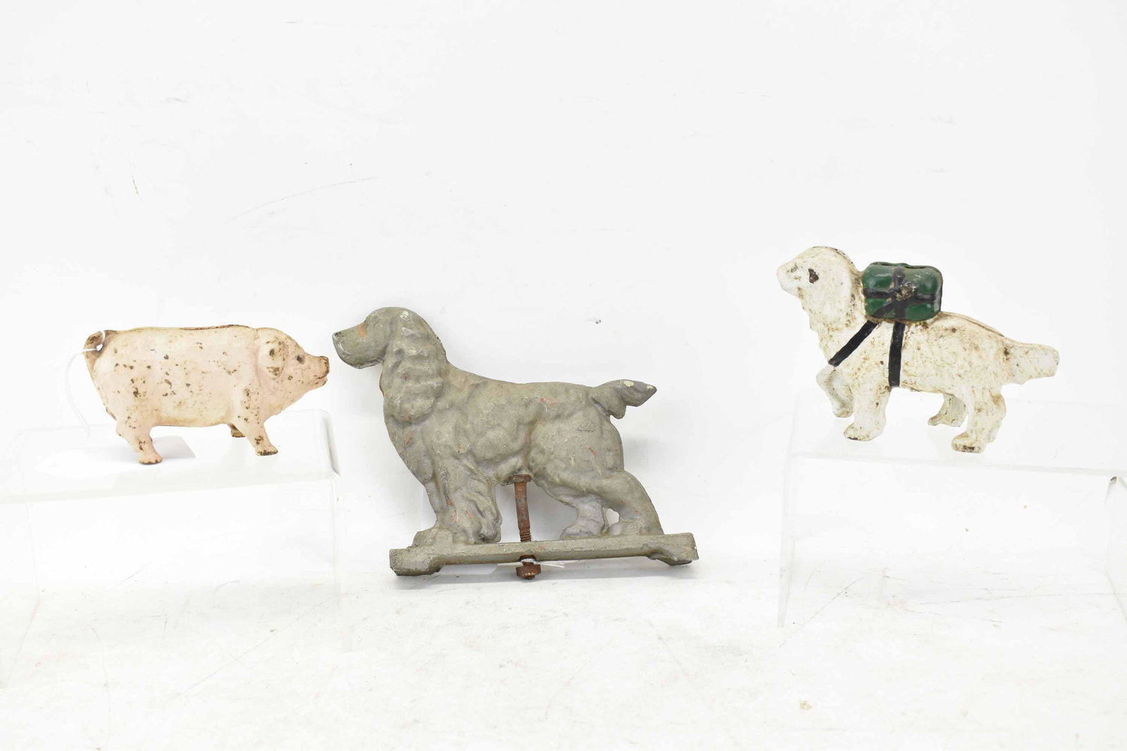 2 Vintage Cast Iron Still Banks: 2 Vintage Cast Iron Still Banks, one with spaniel dog carrying package on back and the other a pink pig, together with a spaniel metal figural mount; used condition, wear/worn, paint loss, surface dis