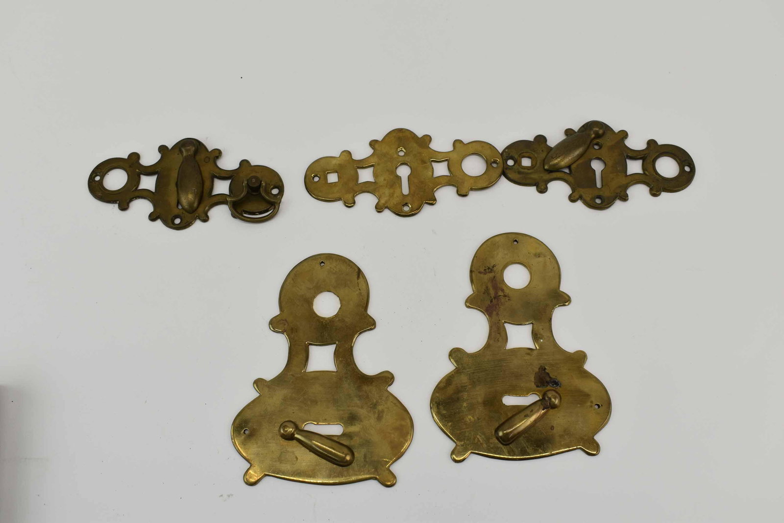 5 Decorative Brass Keyhole Covers Escutcheons: 5 Decorative Brass Keyhole Covers Escutcheons, plates; used condition, wear/worn, largest measures 5 3/4" long x 4 1/8" wide