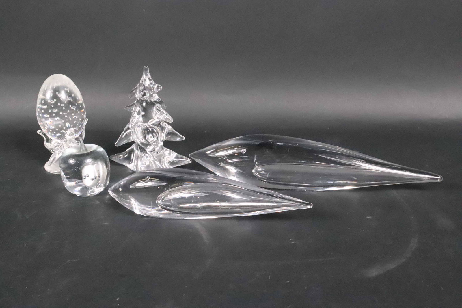 Five Glass Figurines: Comprising, two Kosta Boda abstract teardrops, an apple, a Steuben egg on stand, and a tree, marked underside. Chips, losses.