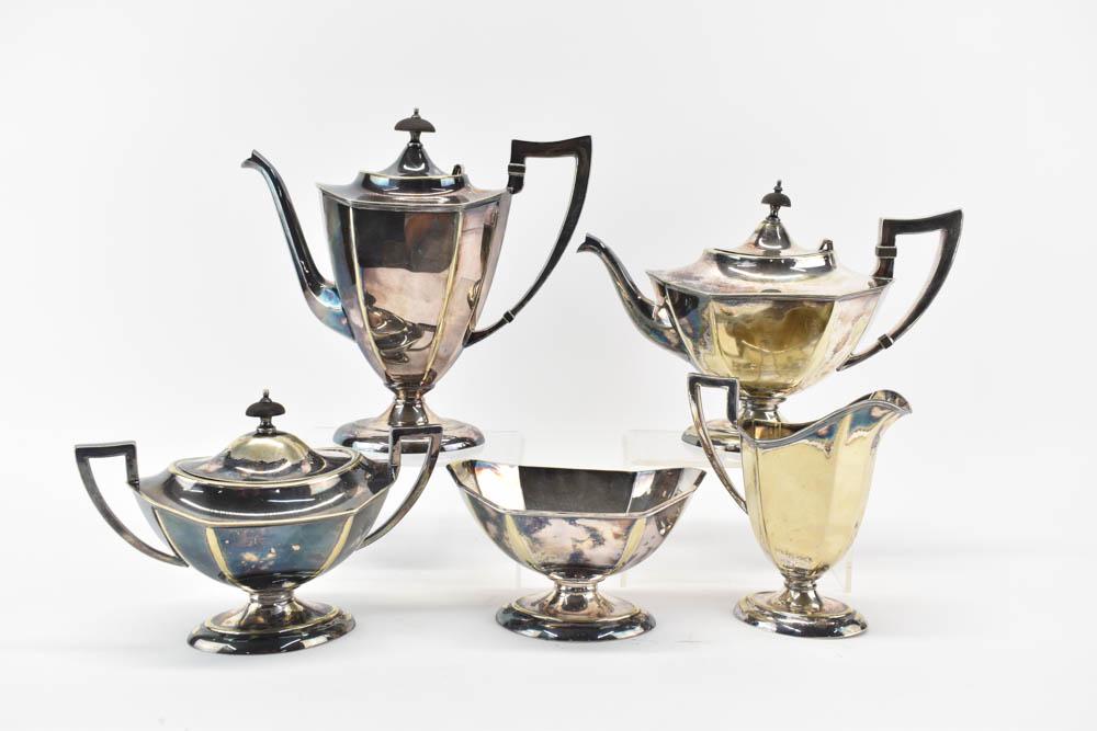 Tea and Coffee Service in Silver Plate: Comprising a teapot, a coffeepot, covered sugar, open waste bowl and a creamer. Losses. 9.5"h