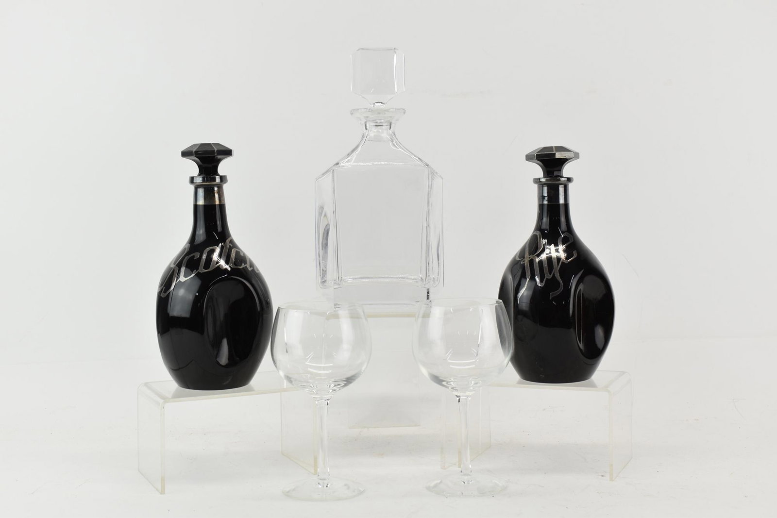 Two Tiffany & Co. Wine Glasses: Two Tiffany & Co. Wine Glasses marked at bottom, together with an unmarked glass decanter and two black glass decanters having metallic overlay label "Rye" and "Scotch", 5 pieces total. Used condition