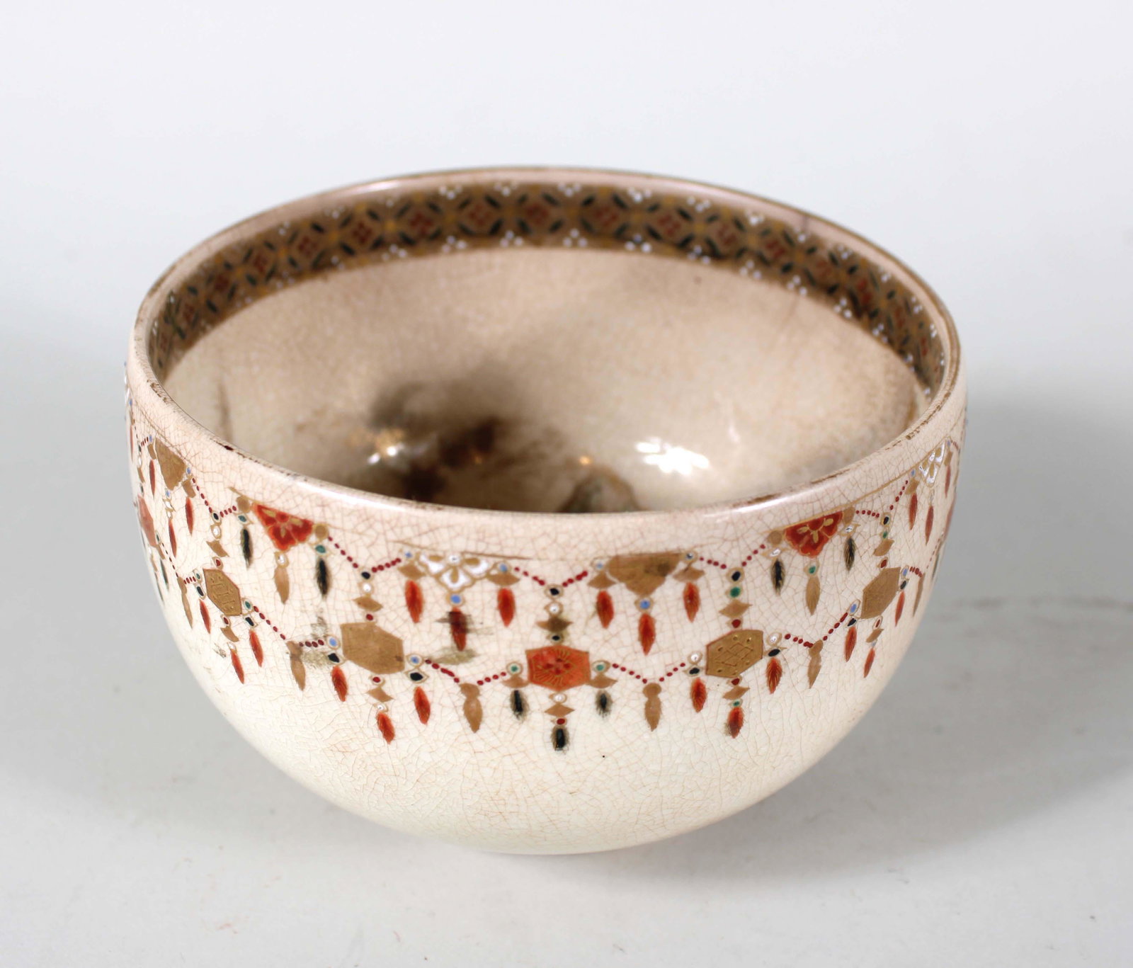 Japanese Satsuma Bowl: Meiji Era or earlier, interior decorated with fanciful mountain scene with couple under a pavilion and visitor approaching by a bridge, exterior decorated with lanterns and tassels 4-1/2"dia Provenanc