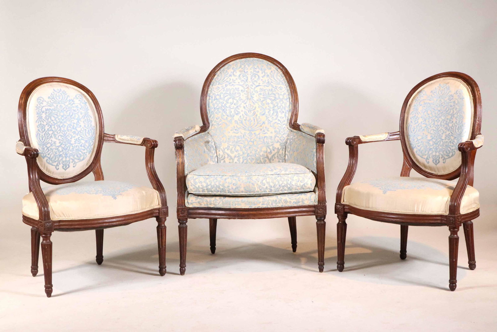 Pair of Louis XVI Mahogany Fauteuils: 18th C. with blue and white upholstery. Together with a Louis XVI mahogany bergere, 3 pieces total Some repairs. Fauteuil: 34"h x 23"w Bergere: 38-1/2"h x 26"w