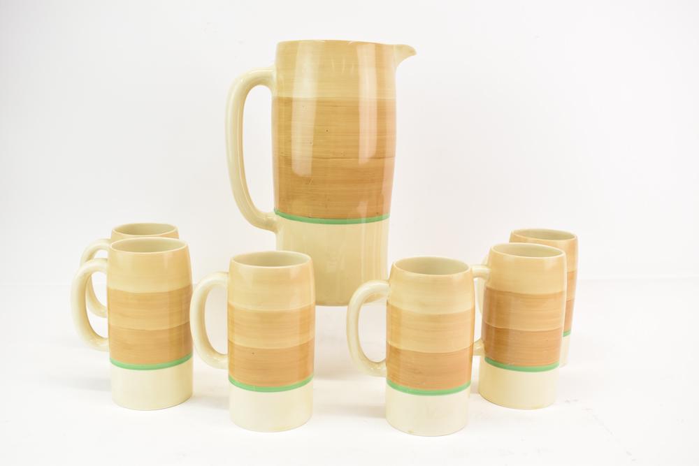 Clarice Cliff Pitcher and Mug Set: Clarice Cliff Pitcher and Mug Set Generally good condition except a few mugs have rim cracks Pitcher: 11"h x 7-1/4"w to back of handle Mugs: each 6-1/4"h