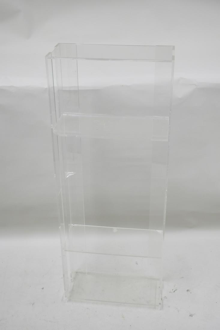 Modern Lucite Four Tier Shelf Display Unit: Modern Lucite Four Tier Shelf Display Unit, used condition with surface wear and one broken shelf. Appx: 49"h x 8-1/2"d x 18-3/4"w.