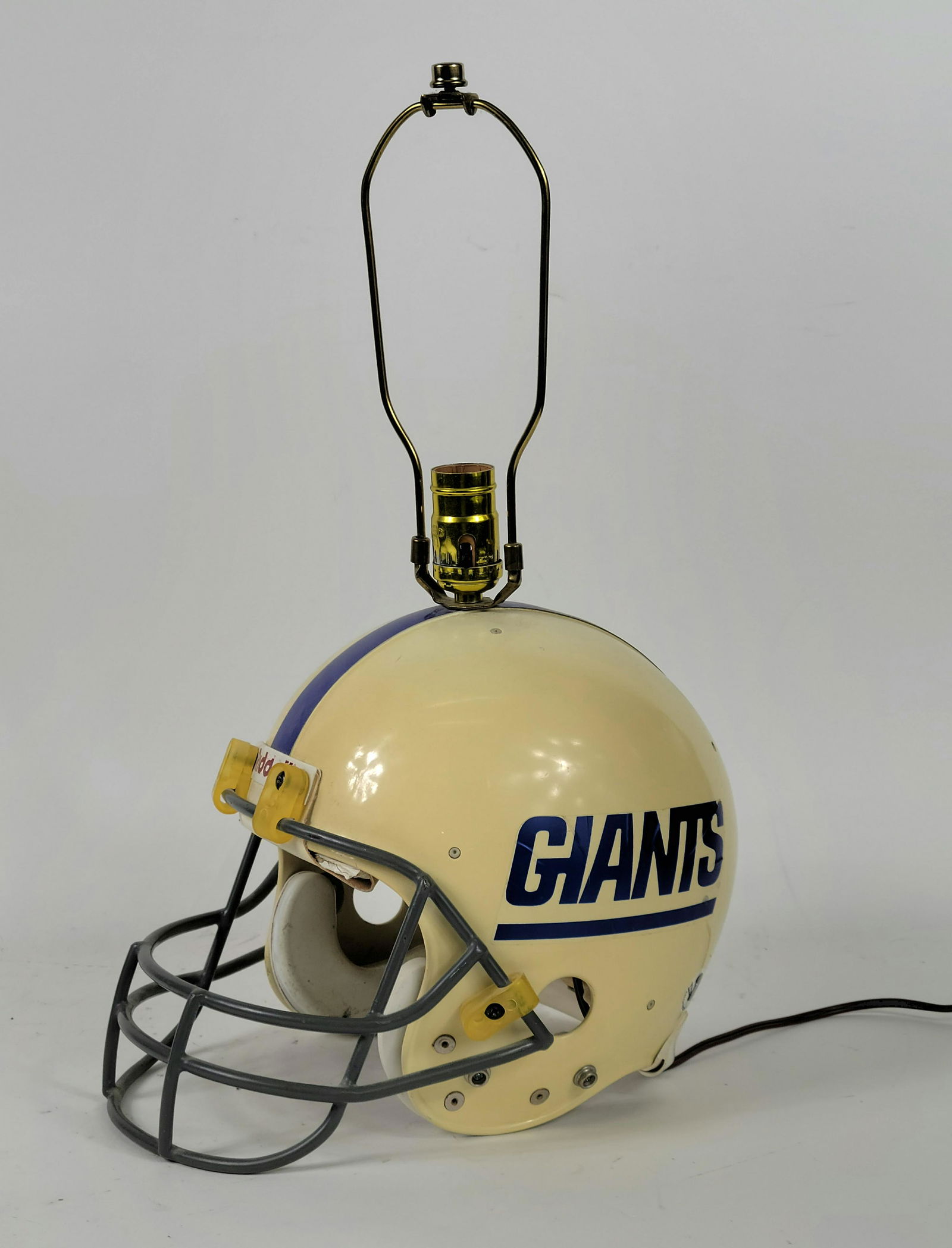 Youth NY Giants Football Helmet Lamp: Youth NY Giants Football Helmet Lamp in overall good condition. Approx. 20" tall. Discolored and some wear to helmet and inside stickers. Unknown working condition. Riddell Branded Helmet. Circa 1992.