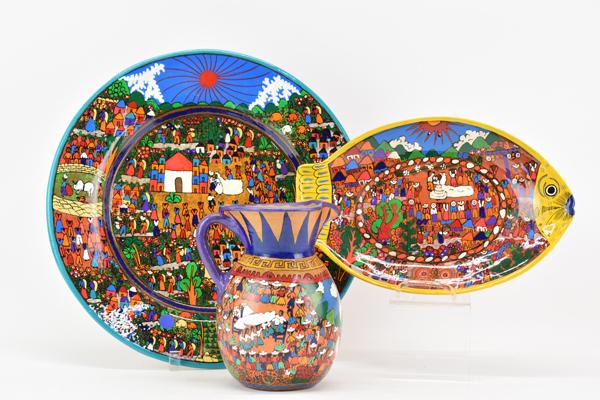 Mexican Folk Art Hand Painted Terracotta Group: Mexican Folk Art Hand Painted Terracotta Group each depicting a wedding scene including a large round wall plate, a fish shaped wall plate and a pitcher (plates have high gloss glaze, pitcher is matte