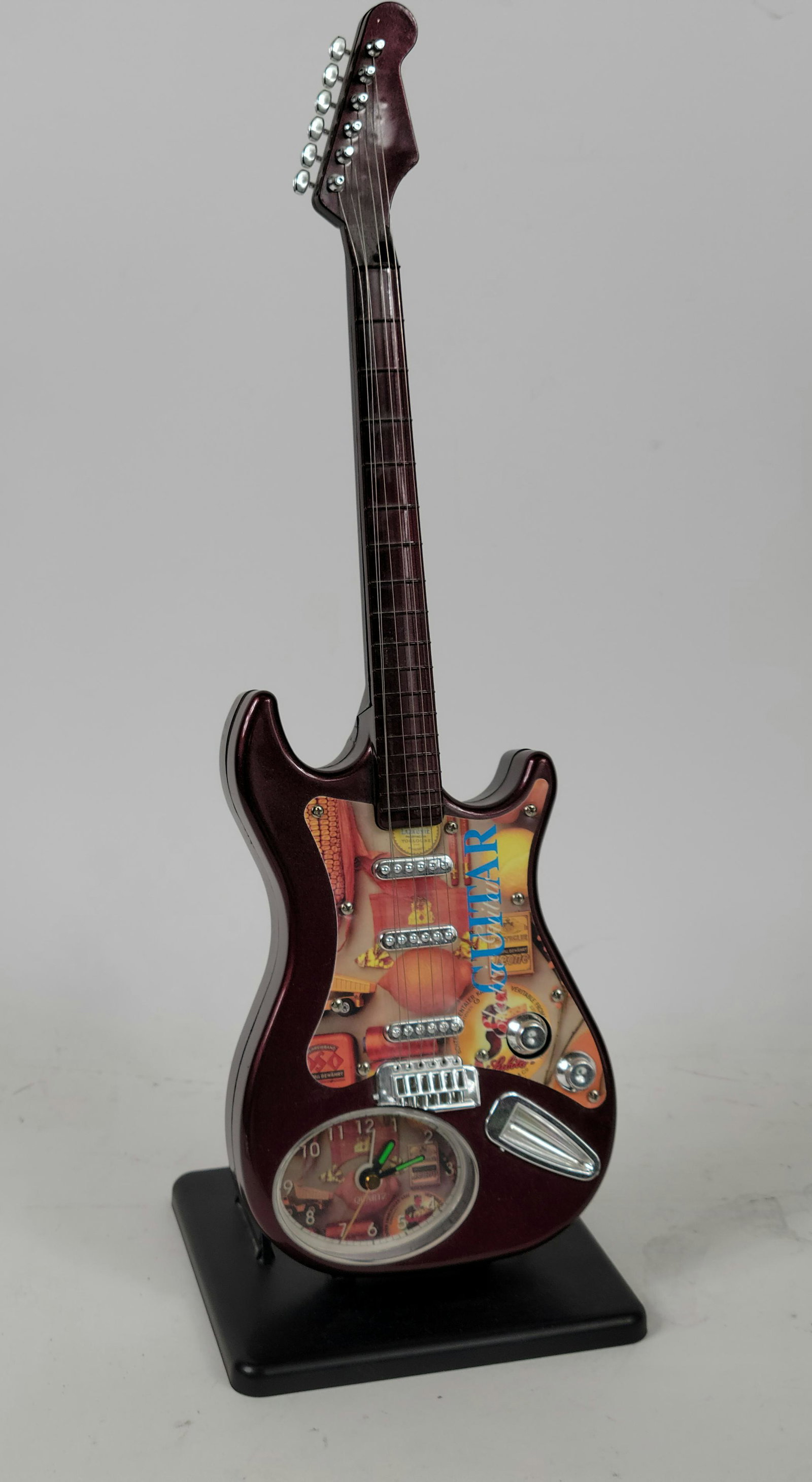 Decorative Abstract Guitar Quartz Clock: Decorative Abstract Guitar Quartz Clock in overall good condition. Unknown working condition. Could use new batteries. approx. 17" tall.