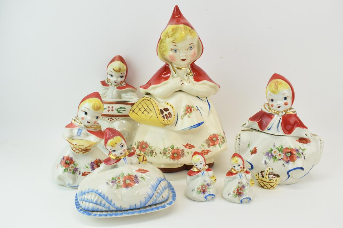 Seven Little Red Riding Hood Porcelain Items: Seven Little Red Riding Hood Porcelain Items comprising two cookie jars, a bank, a butter dish, a hanging basket, and salt and pepper shakers. Wear, chips, surface distress. Tallest: 13"h