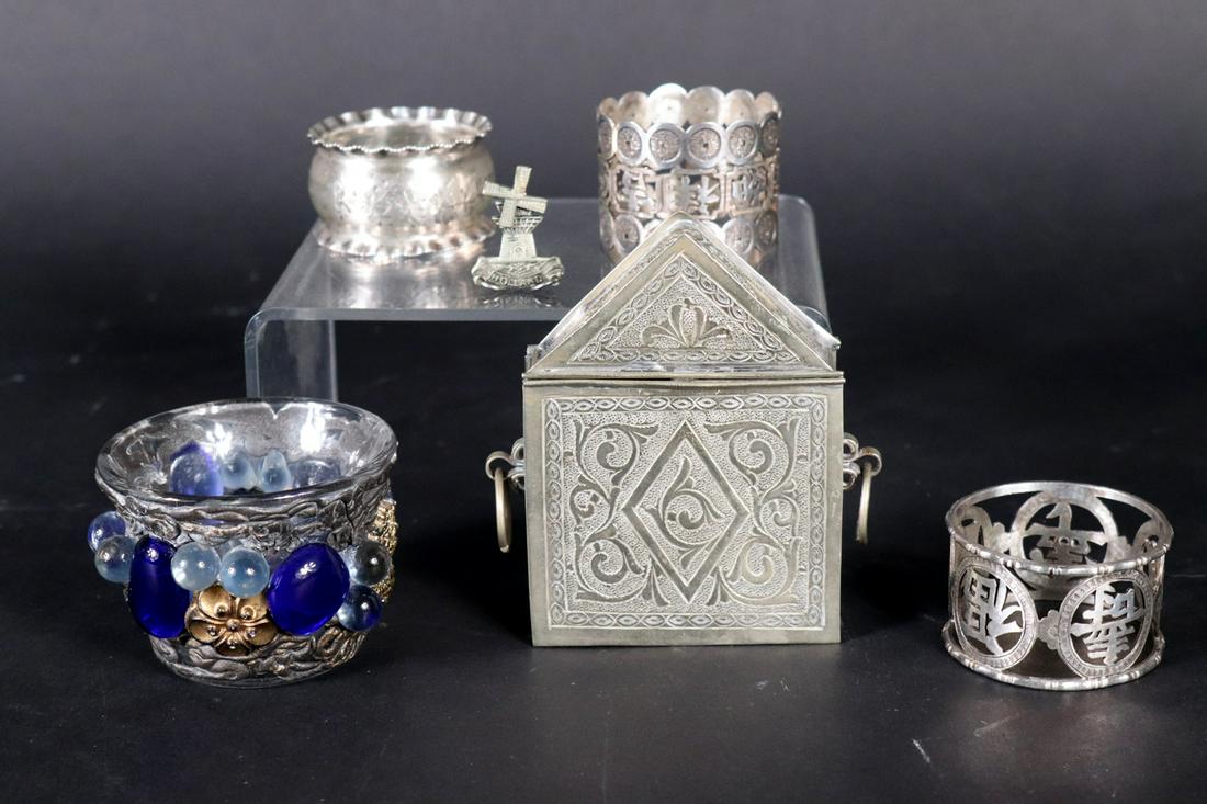 English Sterling Silver Ruffled Napkin Ring: Together with two 90 stamped napkin rings, a metal windmill pin, a metal and faux gem decorated glass votive, and a square silver metal hinged box pendant Provenance: Property from the Estates of Davi