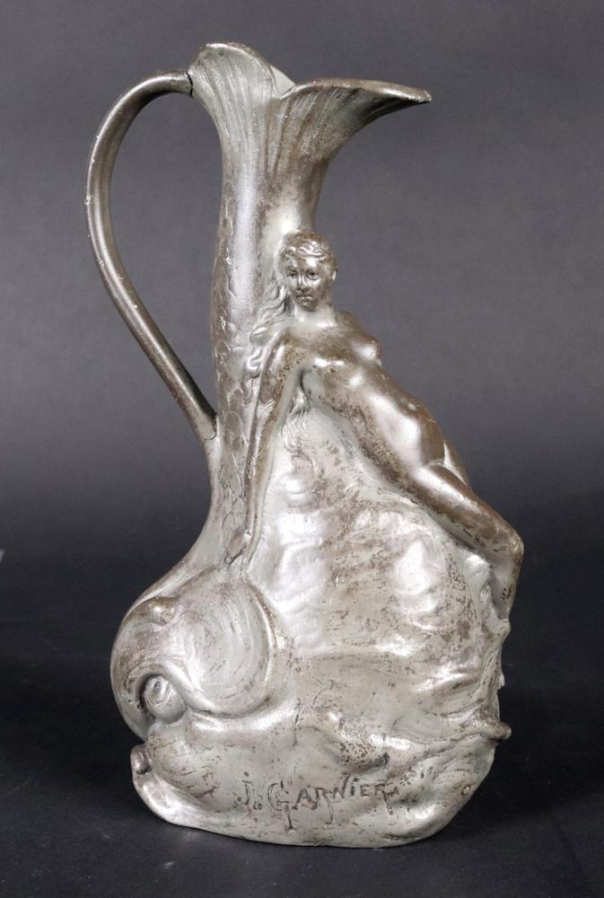 J. Garnier Art Nouveau Figural Dolphin Jug: J. Garnier (1853-1910), ca. 1900, depicting a naked woman and dolphin, stamped on base, "Etain Garanti PUR" Crack to jug handle. 8"h Provenance: Property from the Estates of David and Laura Finn, West