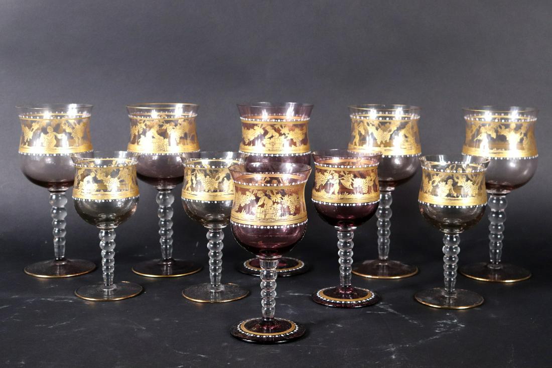 Set of Gilt-Decorated Colored Glass Stemware: Comprising five wine glasses and five sherry glasses, in purple and grey shades, with gilt and white paint decoration. Some wear. 5-1/2"h and 7-1/8"h