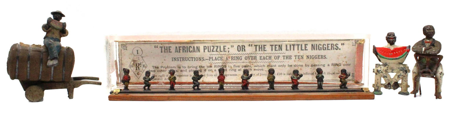 Three Black Americana Painted Lead Figures: Comprising a man on a cotton bale and two seated men; together with "The African Puzzle Game", cast iron ring toss game by an unknown manufacturer, bears English patent mark, with original color litho