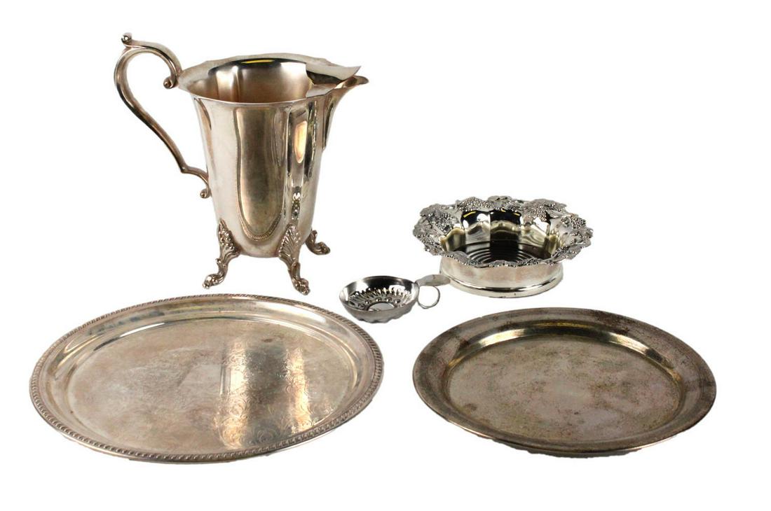Silver Plated Bar and Wine Accessories: Including a grape vine decorated wine bottle holder (7"dia), a wine taster, a footed water pitcher, and two circular trays