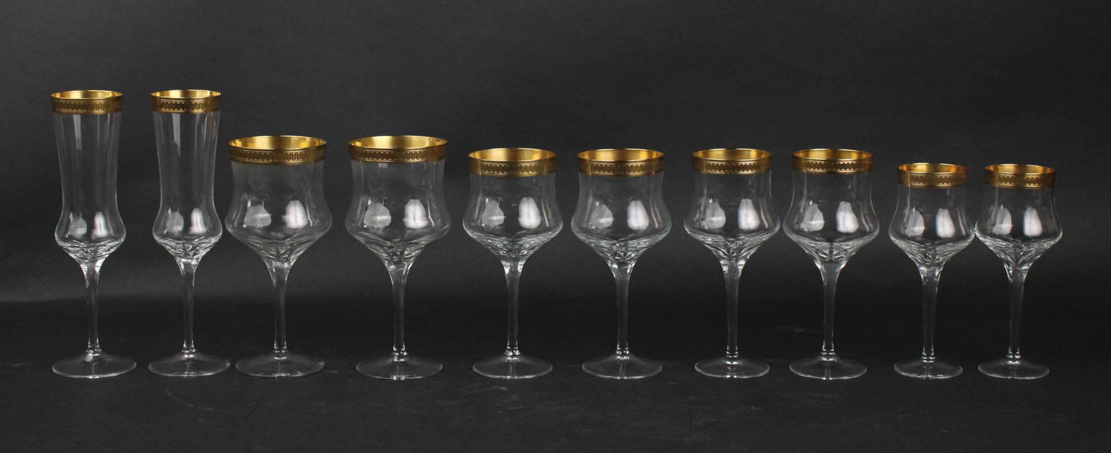 Group of Gilt-Rimmed Crystal Stemware: Comprising 11 champagne flutes, 12 red wine glasses, 23 white wine glasses, and 12 claret glasses. Provenance: Property from the Collection of Maggie Cohen, New York City