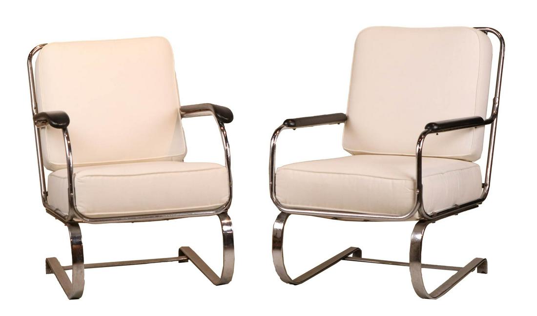 Two Kem Weber Art Deco Chrome Lounge Chairs: With ebonized armrests and white upholstered cushions. Some wear, surface distress. 33-1/2"h x 25"w x 29"d