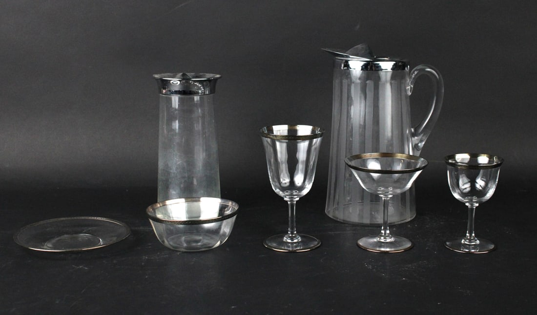 Group of Silver Rimmed Stemware: Comprising, 8 wine glasses, 10 sherry glasses, 7 champagne coupes, 15 plates, 12 bowls, and two pitchers. 54 pieces Some wear. Provenance: Property from a Private Princeton, NJ Collection
