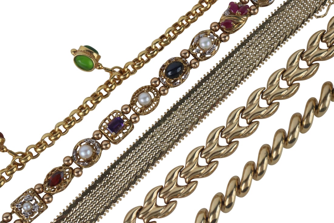 Four 14K Yellow Gold Link Bracelets: All stamped 14k, including a San Marco link, swirl link, woven gold, round link as a charm bracelet with three gemstone set lantern form charms, each 7"l, total gross weight approx. 49.0dwt. Together