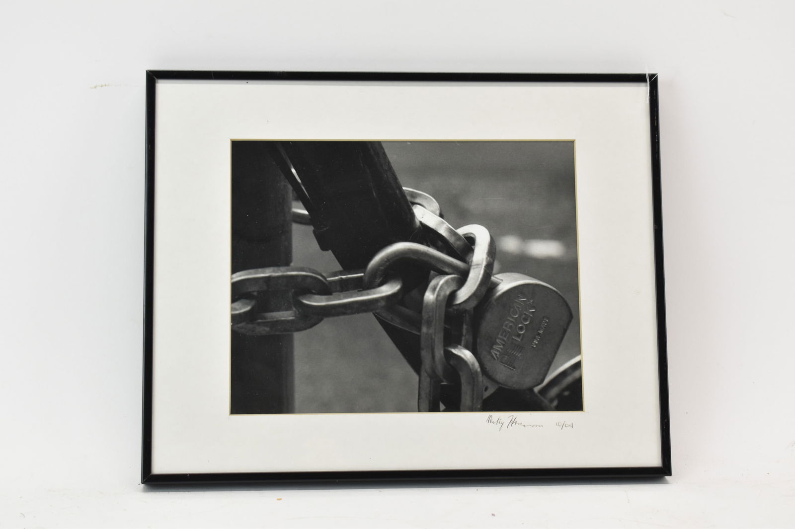 Black and White Photograph of a Lock and Chain: Black and White Photograph of a Lock and Chain, signed on the mat illegibly and numbered 10/04. Sight size: 7-1/2"h x 9-1/2"w Overall: 11-1/4"h x 14-1/4"w