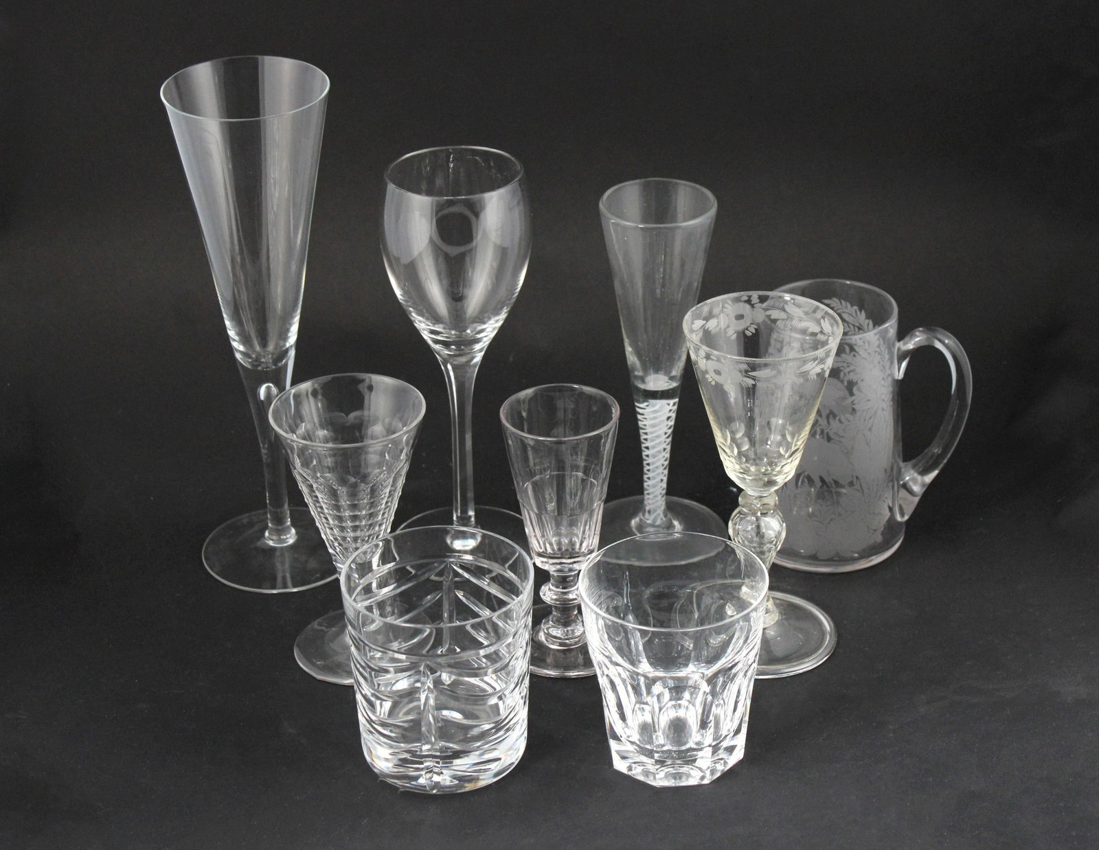 Twelve Waterford Crystal Tumblers: Together with 11 Royal tumblers, 12 parfait glasses, 3 parfait glasses, a pitcher, an etched glass, a spiral stem glass, 4 tiffany wine glasses, and 4 large champagne glasses. 49 pieces Chips, wear. P