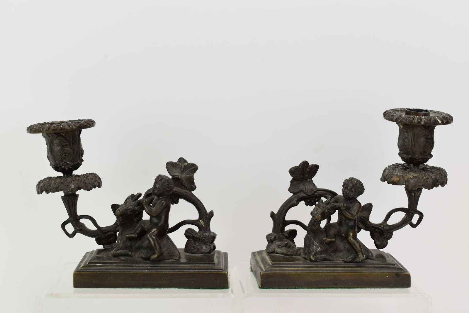 Pair of Vintage Bronze Candleholders With Child & Goat: Pair of Vintage Bronze Candleholders With Child & Goat Pair of Vintage Bronze Candleholders each with Child Seated on Goat and floral branch for tapered candle and stepped rectangular base, weighted; 