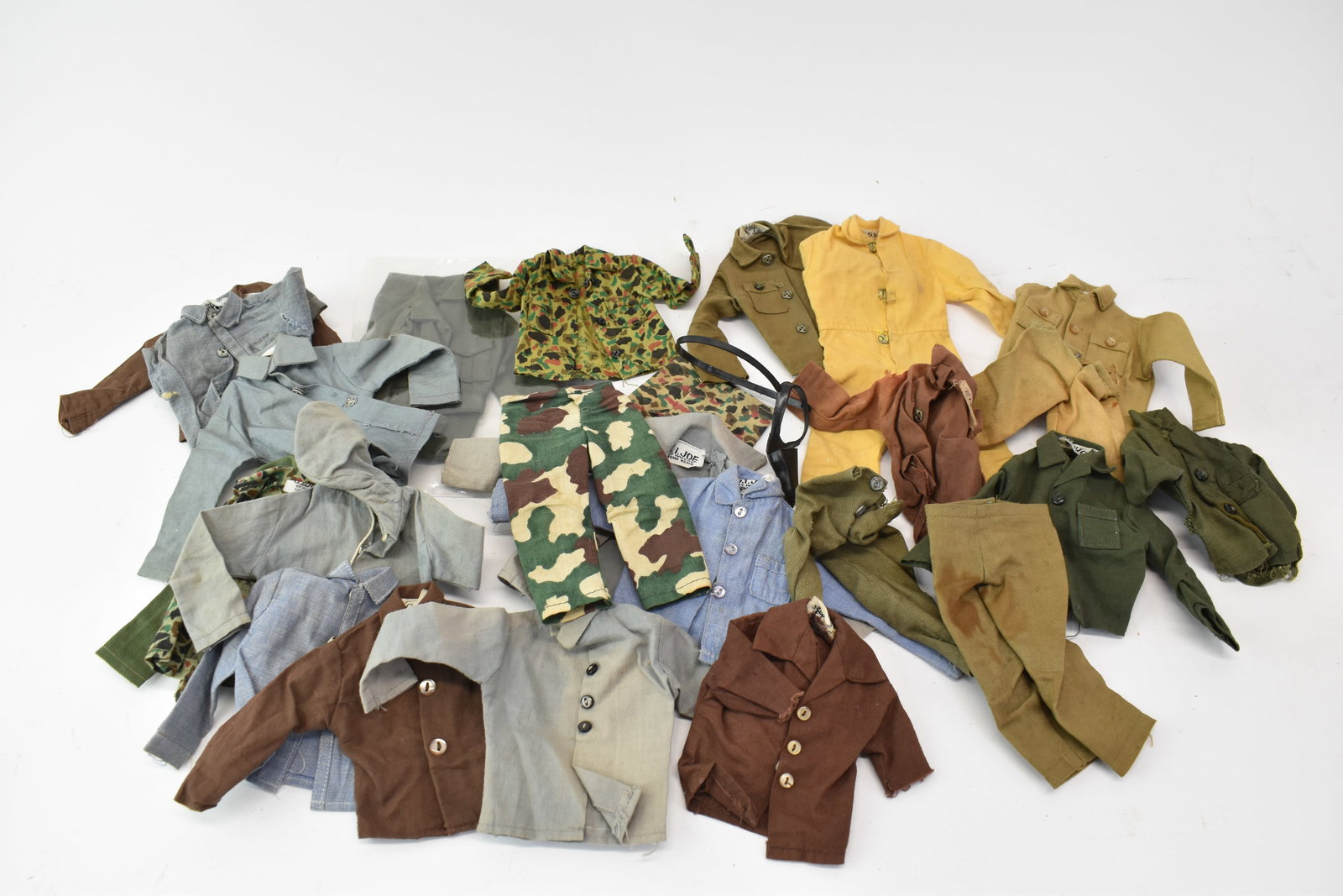 Vintage GI Joe Hasbro Uniforms: Vintage GI Joe Hasbro Uniforms Vintage GI Joe Hasbro Uniforms, many with tags reading "Hong Kong," several chambray articles, some camofalge, khaki shirts and pants, a boiler suit. Used cond