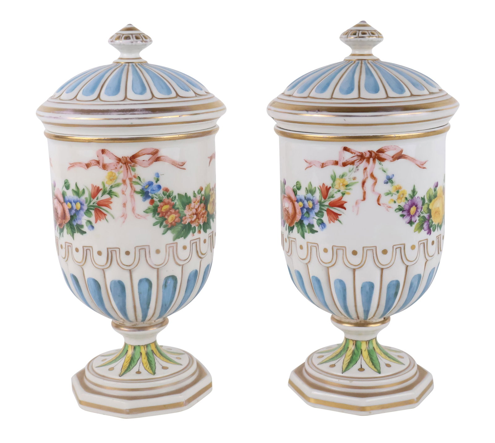 Pair of Continental Porcelain Covered Urns: Pair of Continental Porcelain Covered Urns 20th C. each decorated with floral swags over a part-fluted body. Repairs and losses to both lids. Provenance: Property From The Estate of Barbara Mallory Ha