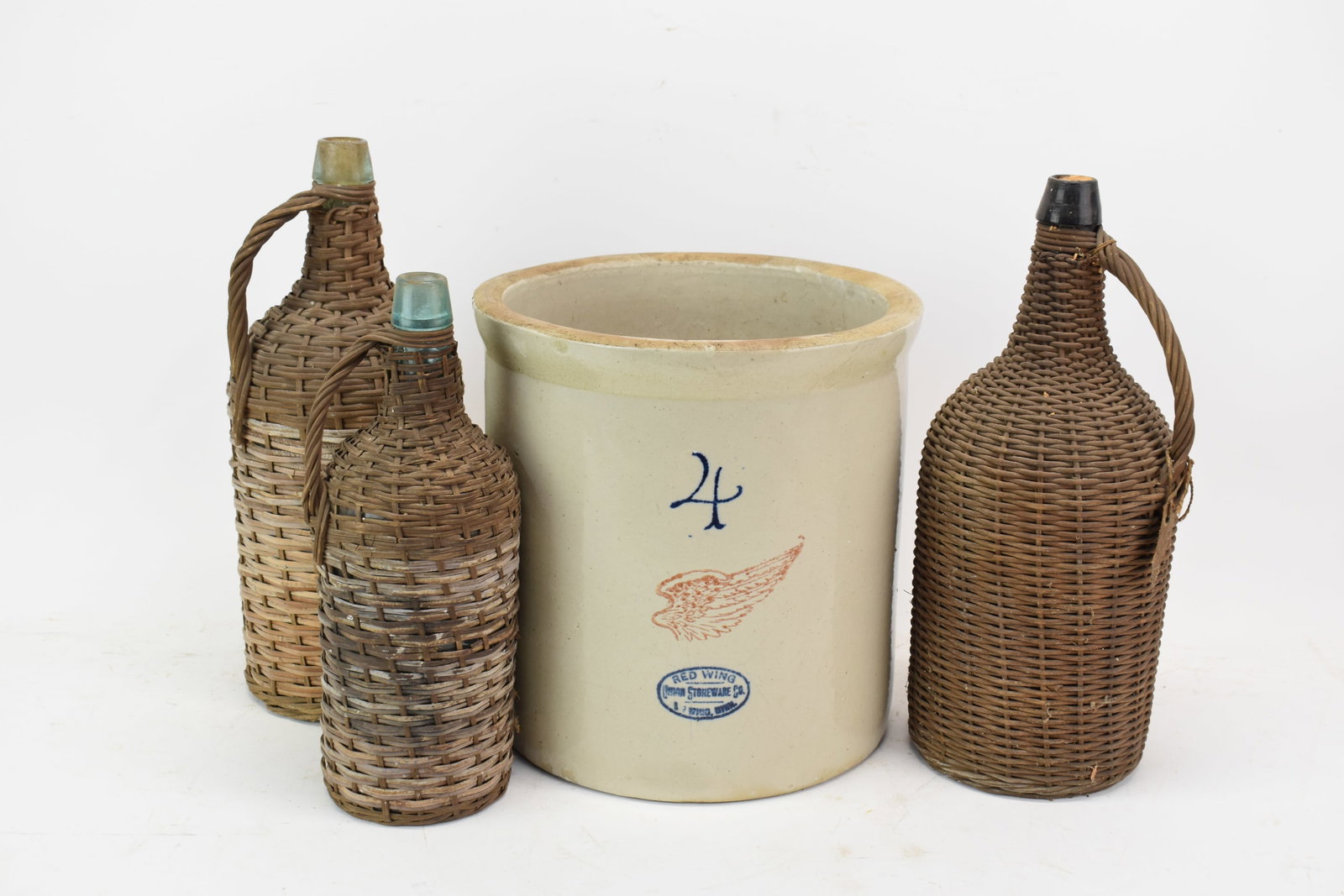 Large 4 Gallon Redwing Stoneware Crock: Large 4 Gallon Redwing Stoneware Crock. Together with three Antique glass bottle wine jugs with wicker exteriors. Used condition, wear, worn, Crock size 12" tall x 11 3/4" diameter