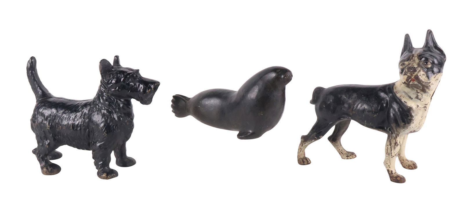 Two Dog Form Cast-Iron Doorstops: Two Dog Form Cast-Iron DoorstopsComprising, a Scottie and a Boston terrier. Together with a carved stone seal, with paper Eskimo label.Largest: 9 1/2 x 9 x 3 1/2 in. (24.1 x 22.9 x 8.9 cm.)