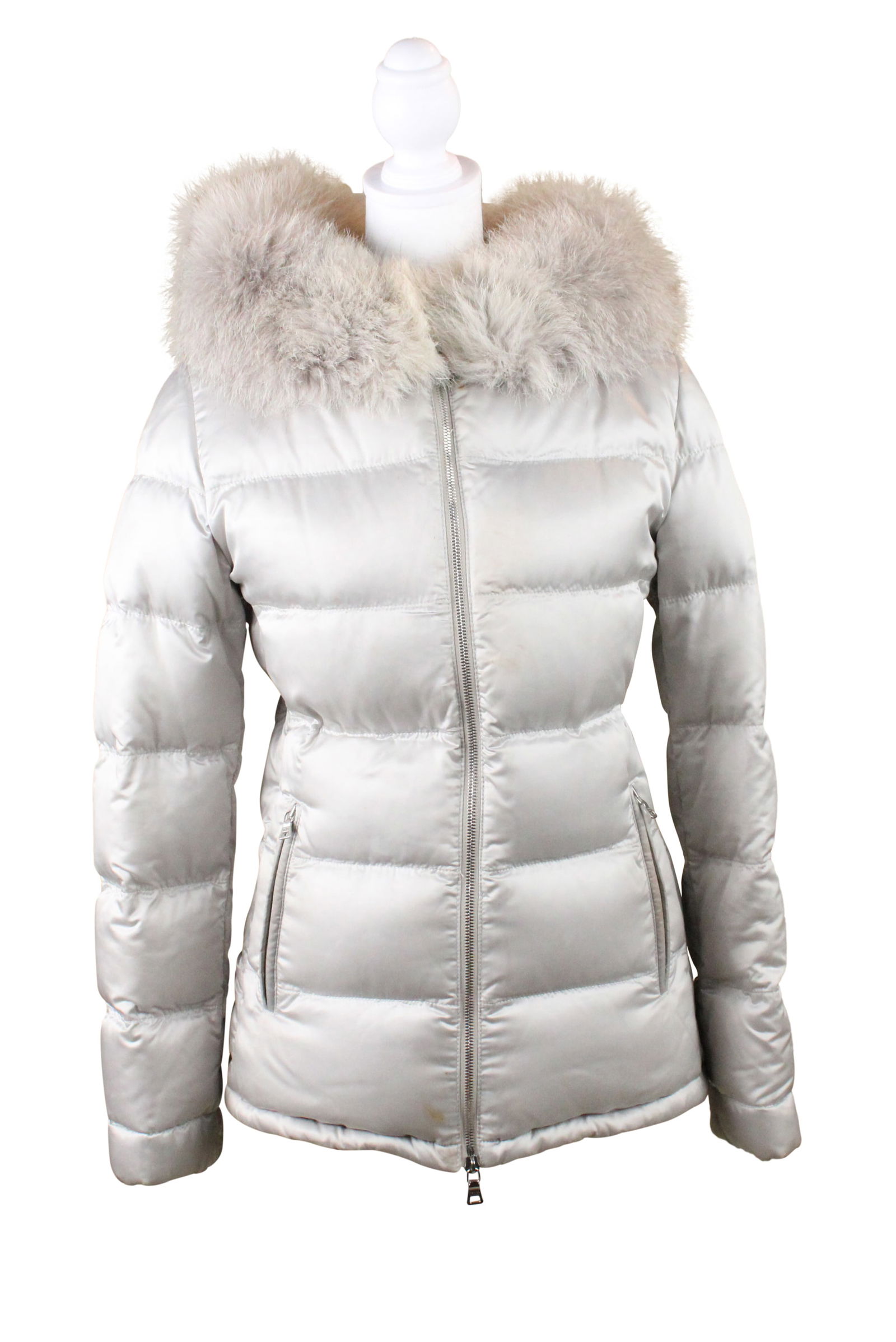 Prada Silver Puffer Jacket: Prada Silver Puffer JacketUnknown size and materials, label cut out, fur or faux-fur lined hood.Stains, Wear associated with use.Provenance: The Estate of Susan Chalom, New York, NY24 1/2 x 16 in. (62