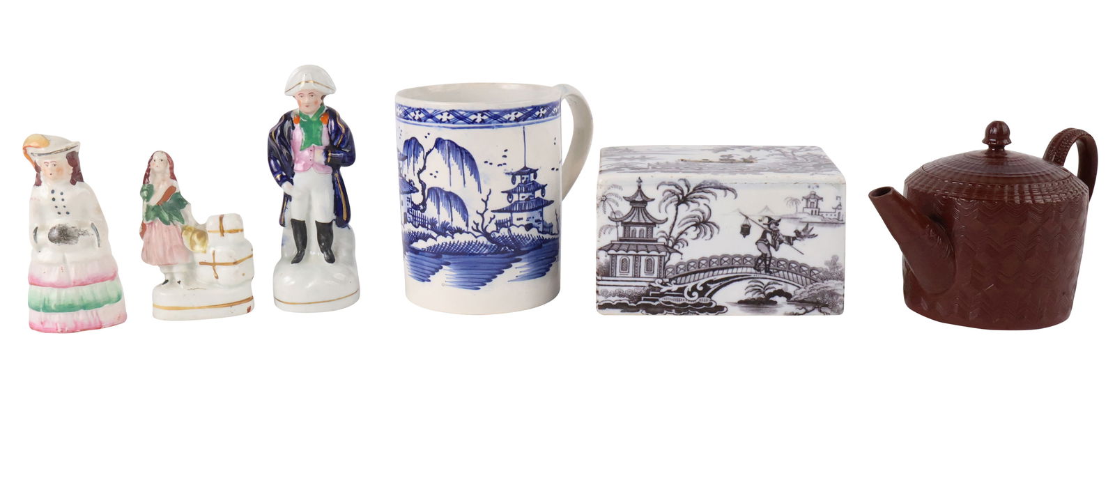 Six English Porcelain Table Articles: Six English Porcelain Table ArticlesComprising, three Staffordshire figurals, a transferware money box, a pearlware mug, and a glazed redware teapot, Engine turned.Money Box: 3 x 5 x 3 1/2 in. (7.6 x