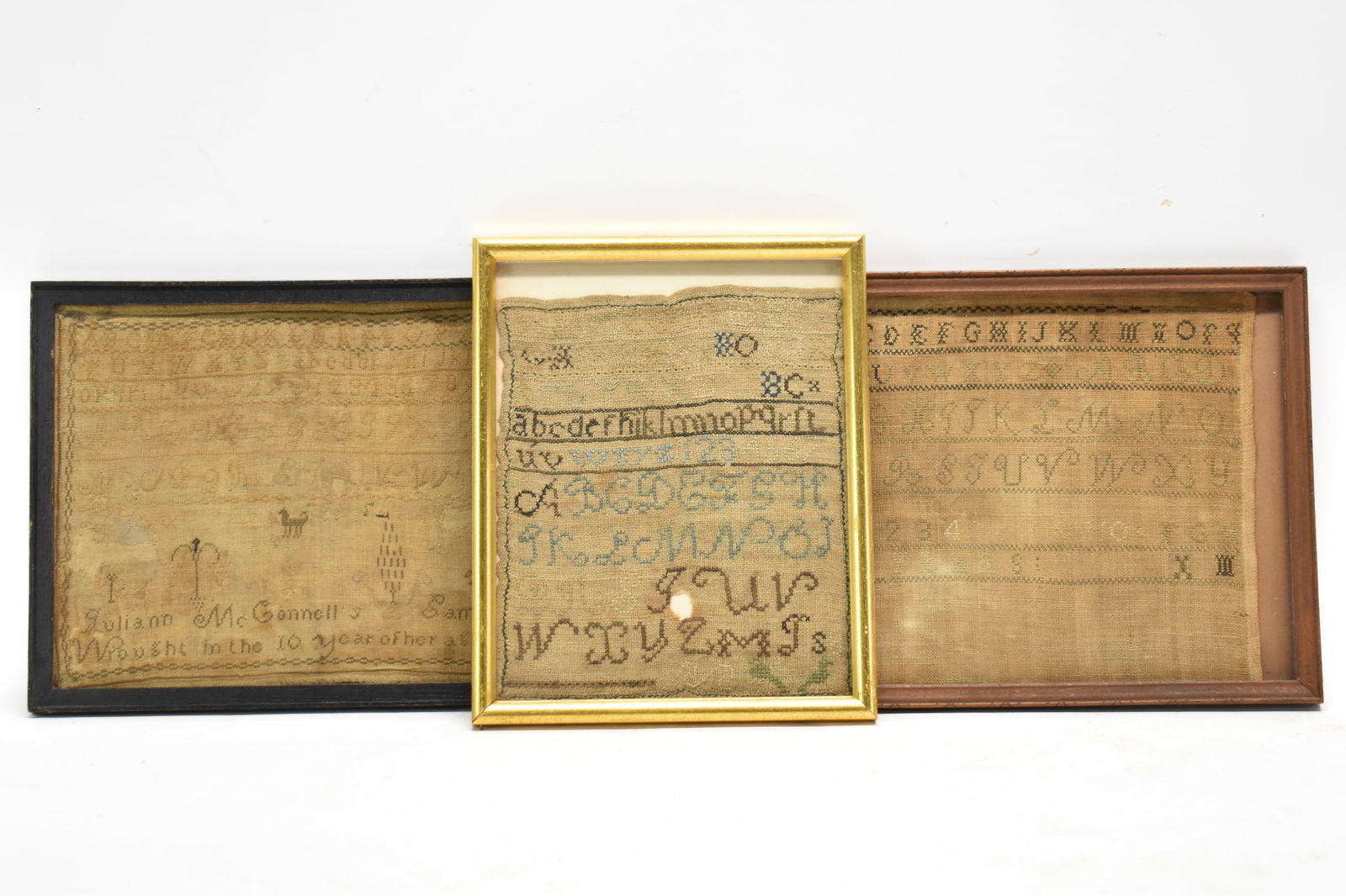 Sampler By Juliann McConnell Dated 1818: Sampler By Juliann McConnell Dated 1818Sampler By Juliann McConnell Dated 1818, together with two other antique samplers, all in wood frames (one brown, one black, one gilt); used condition, wear/worn