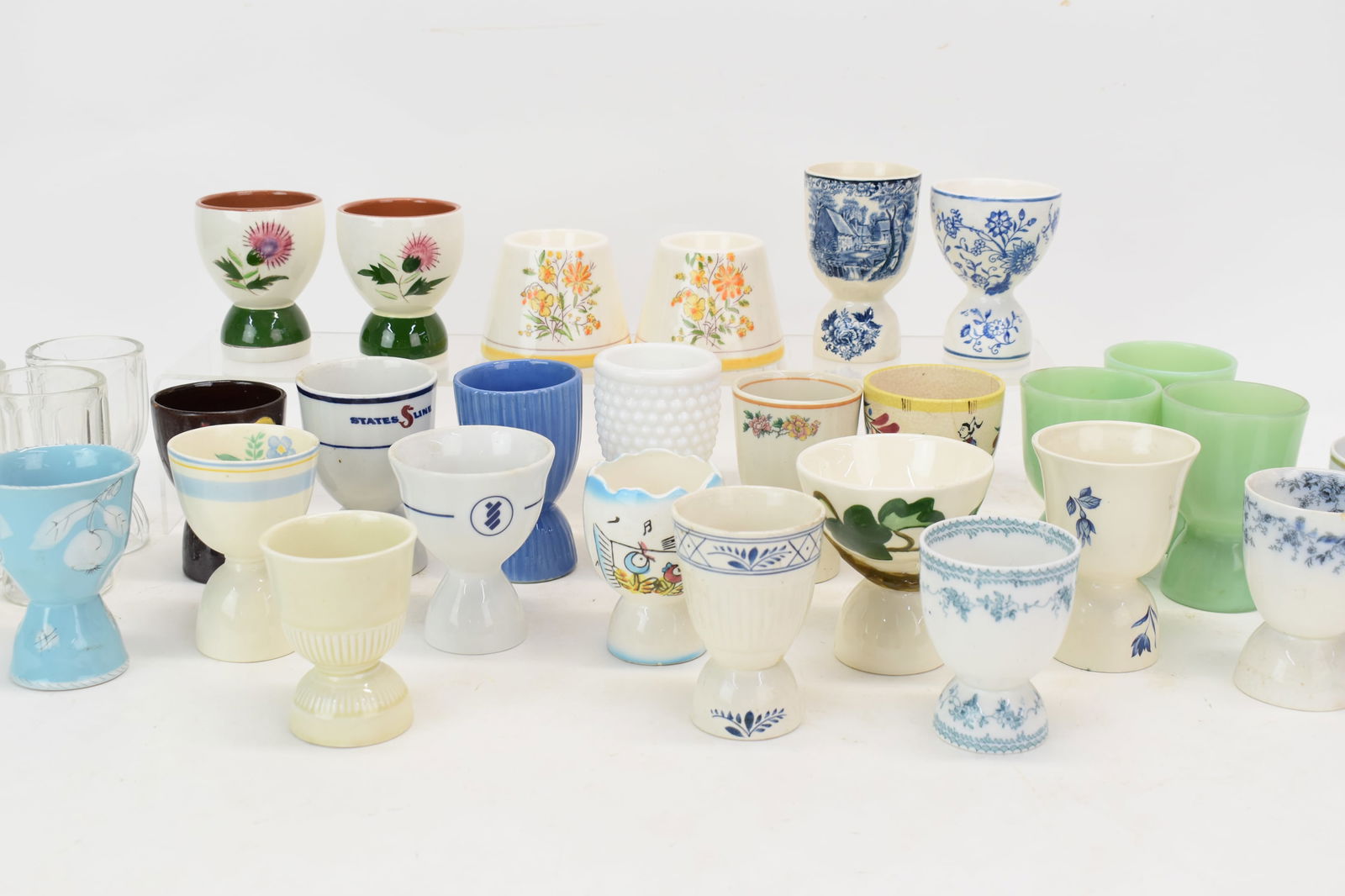 Vintage Group of 30 Assorted Egg Cups: Vintage Group of 30 Assorted Egg CupsVintage Group of 30 Assorted Egg Cups. Including three Jade Colored glass egg cups, PAIR OF Peint A La Main Au Bresil egg cups and other decorated cups. Used condi