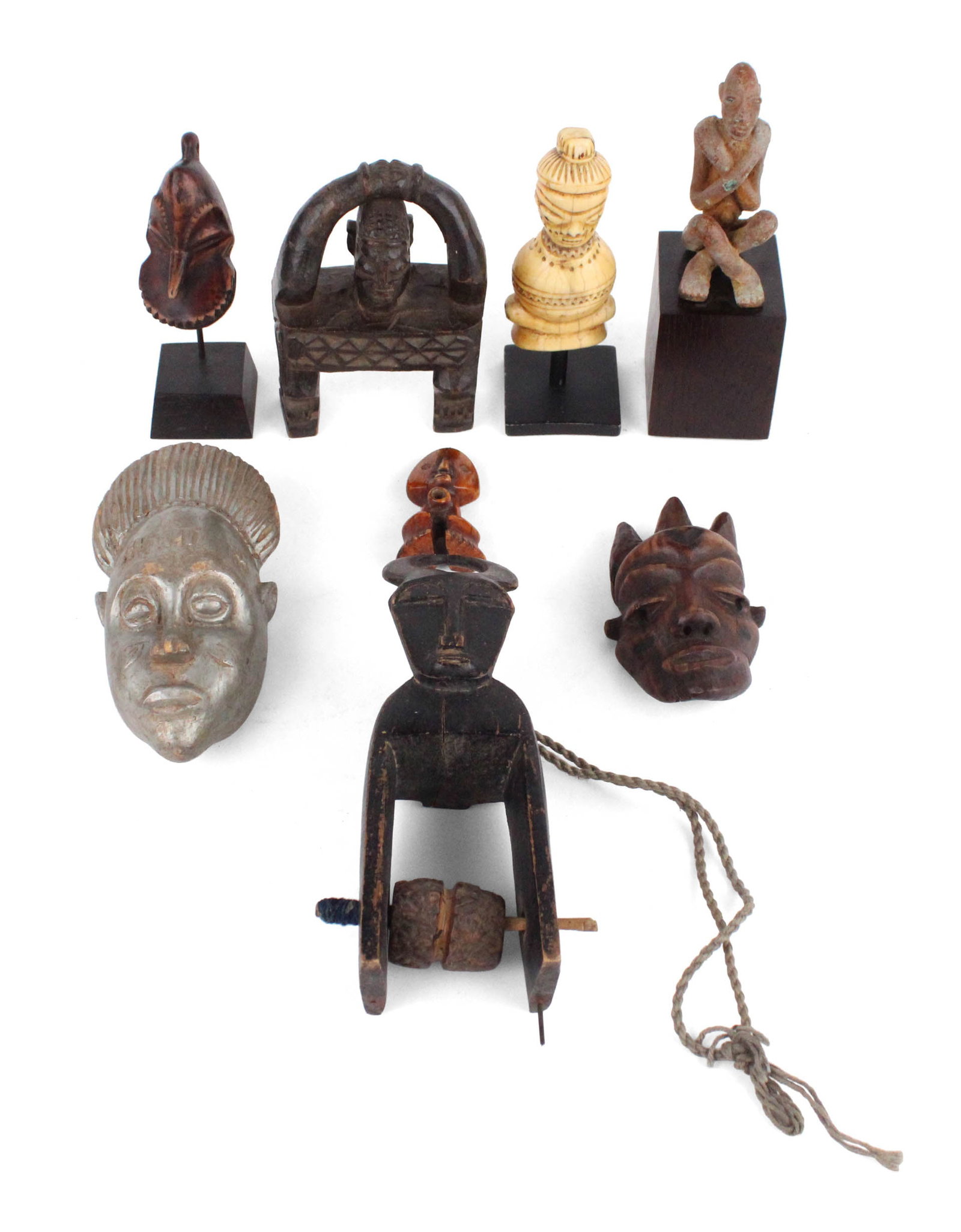 Group of African Small Objects: Group of African Small ObjectsIncluding masks, a carved bone figure, a painted metal figure, and a Heddle pulley.Surface distress and wear.Largest: 7 x 3 1/2 in. (17.8 x 8.9 cm.)