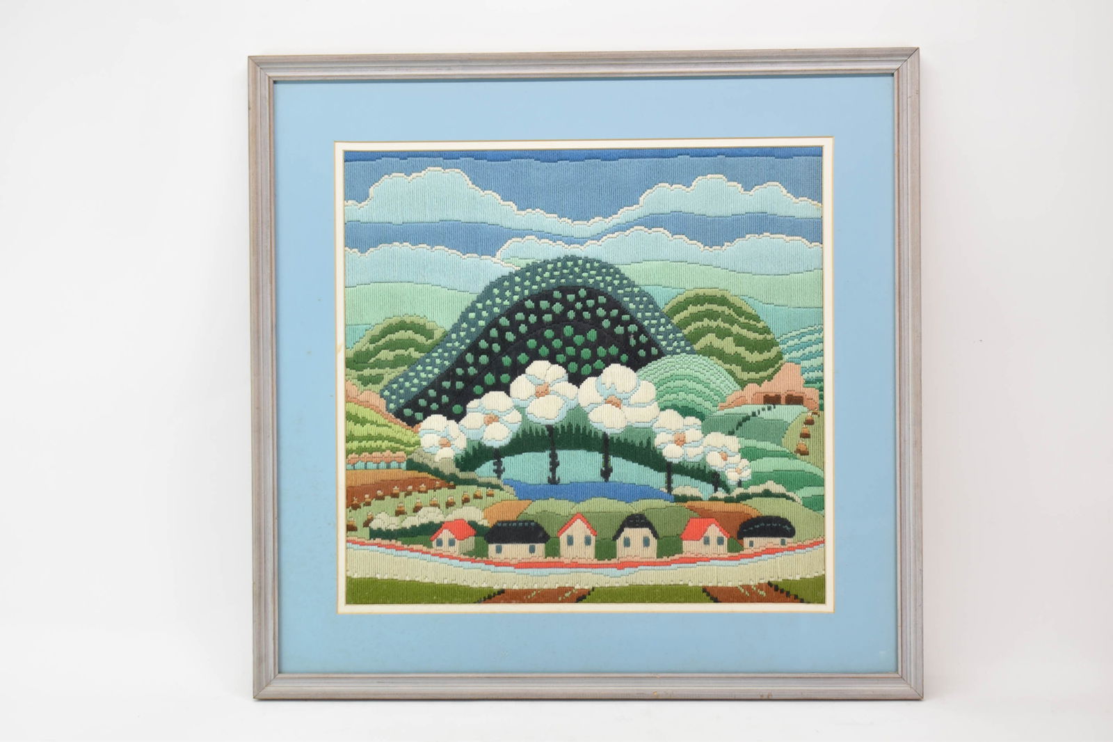 MCM Needlepoint Yarn Landscape: MCM Needlepoint Yarn Landscape MCM Needlepoint Yarn Landscape in vibrant colors in gray wood frame with light blue mat; used condition; not excamined outside of frame, foxing to matting, measures
