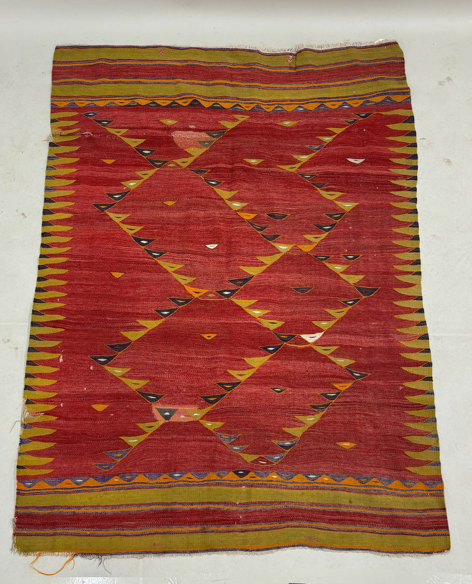Kilim Area Rug: Kilim Area Rug Kilim Area Rug having central red ground with geometric and striped pattern. Used condition wear, worn, holes, tears, losses. 79" x 55"
