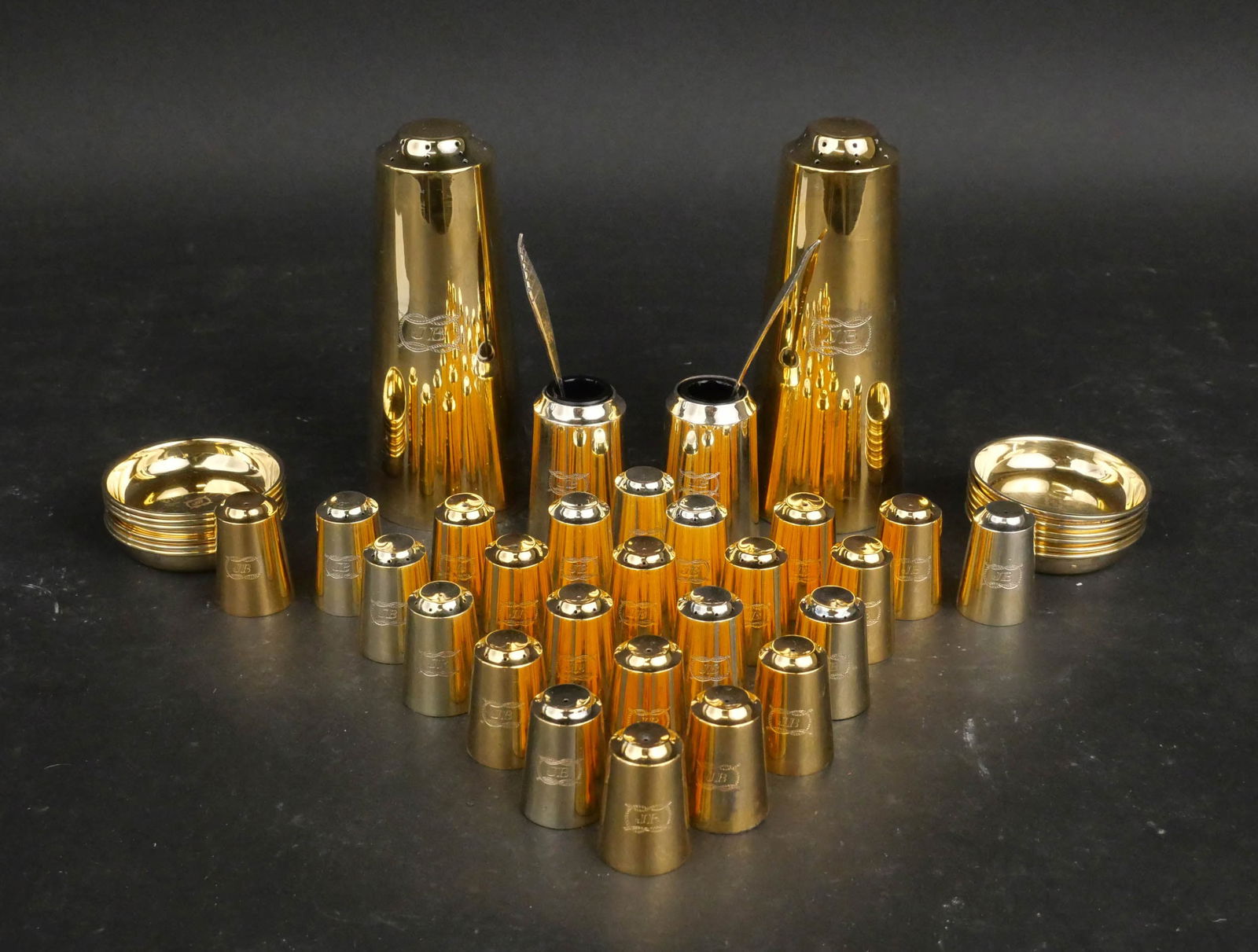 Collection of R W Buridge Gilt Silver Tableware: Collection of R W Buridge Gilt Silver Tableware English, 1960's. Comprising: two tall shakers, two master salt spoons, two salt cellars with blue glass liners, and twenty-four individual shakers.