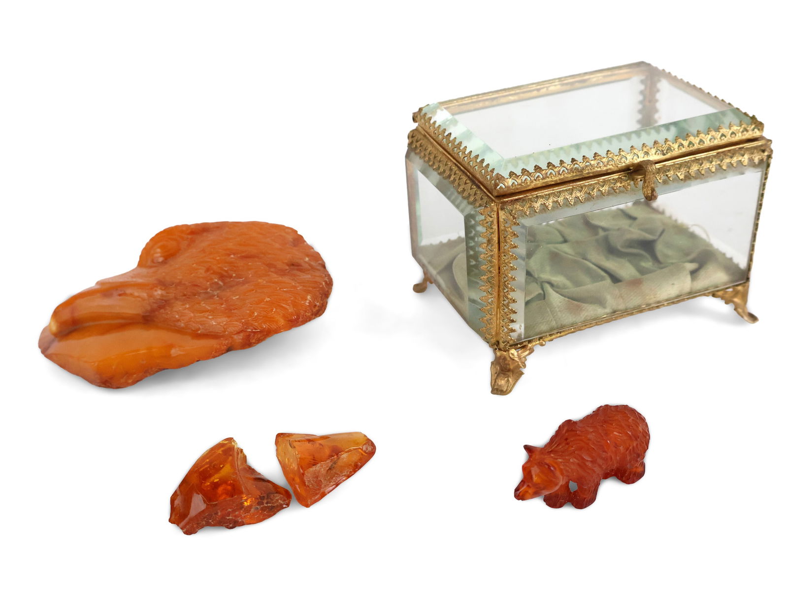 Collection of Amber: Collection of Amber Including, a carved Russian bear, an eagle's head in butterscotch amber, and two raw nuggets with inclusions. Together with a small gilt-metal and glass display case. Eagle: 3 x