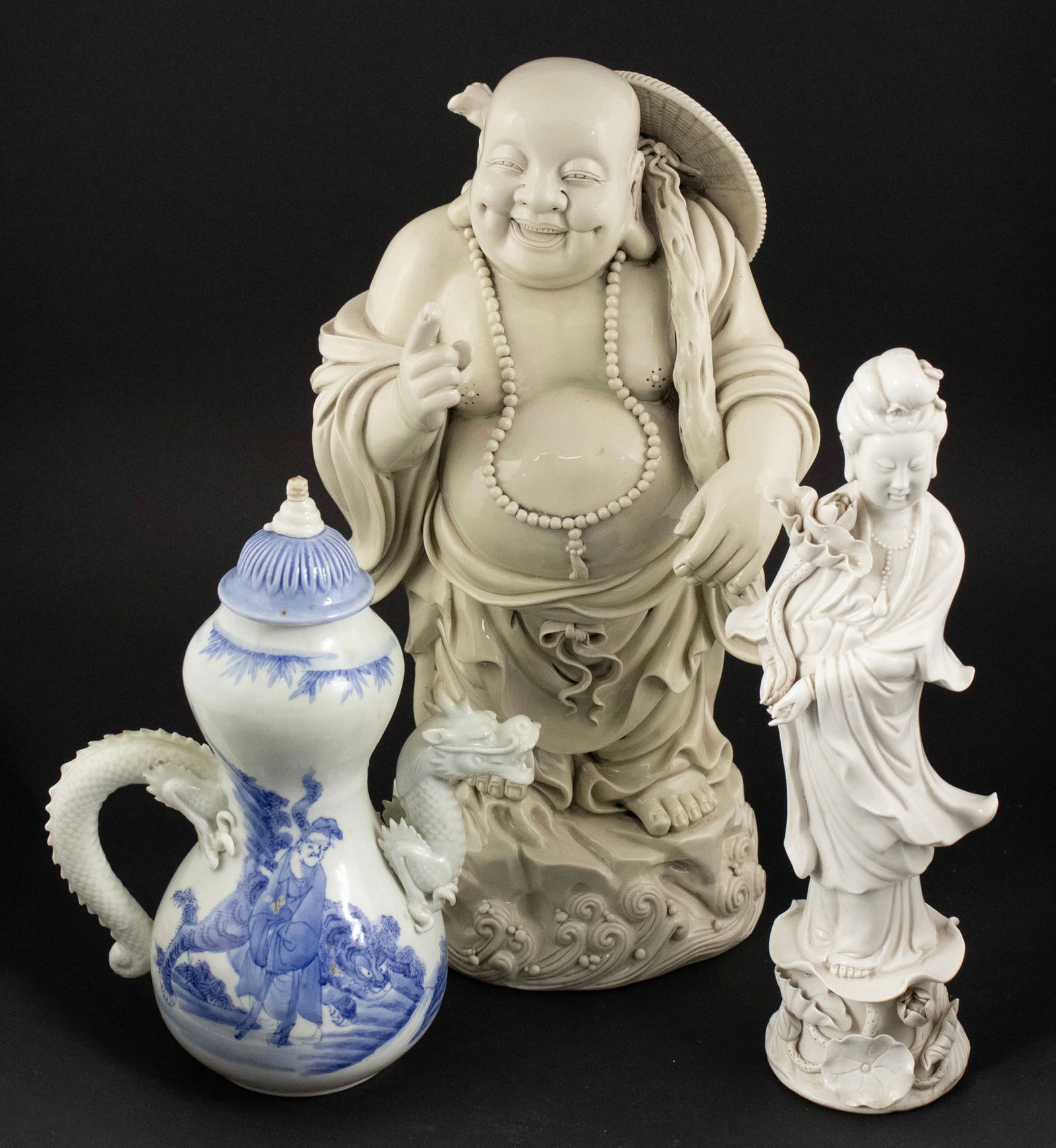 Chinese White Glazed Laughing Buddha Figure: Chinese White Glazed Laughing Buddha Figure Together with a Chinese white glazed Guanyin figure and a blue and white teapot with dragon form handle and spout. 3 pieces Losses, wear. Buddha: 14 3/4 x