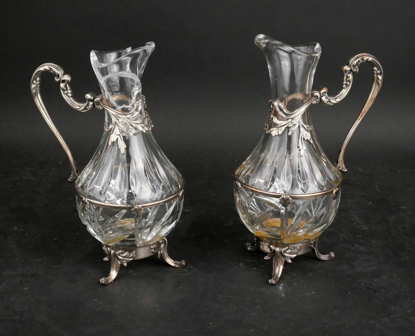 Pair of Silver Plated and Glass Pitchers: Pair of Silver Plated and Glass Pitchers Crack to pitcher, wear, worn, losses. 10 in. (25.4 cm.)