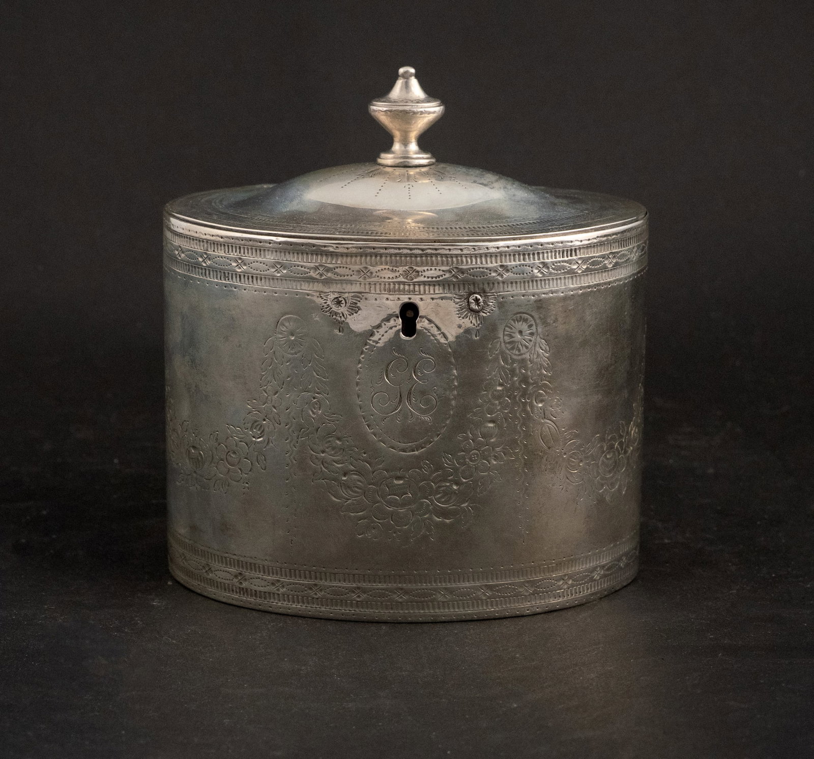 George III Silver Oval-Form Tea Caddy: George III Silver Oval-Form Tea Caddy John Denzilow, London 1782. With urn finial. Approx. 11 t.o. Bright cut decorated with Neoclassical festoons and floral garlands centering two sets of initials,
