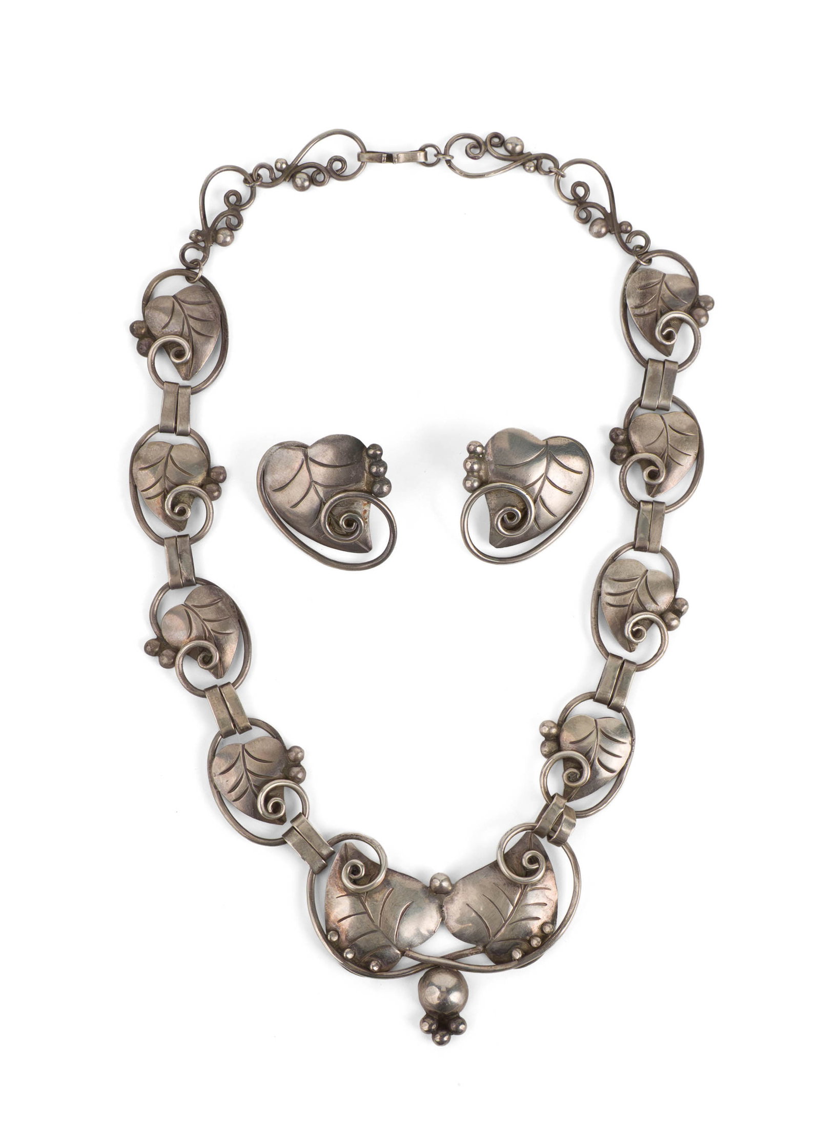 Mexican Silver "Silver Leaf" Suite of Jewelry: Mexican Silver "Silver Leaf" Suite of Jewelry Copy of the Georg Jensen silver leaf suite, with necklace and matching earrings. Center pendant on necklace marked "Sterling" "Mexico", c. 1950. Total