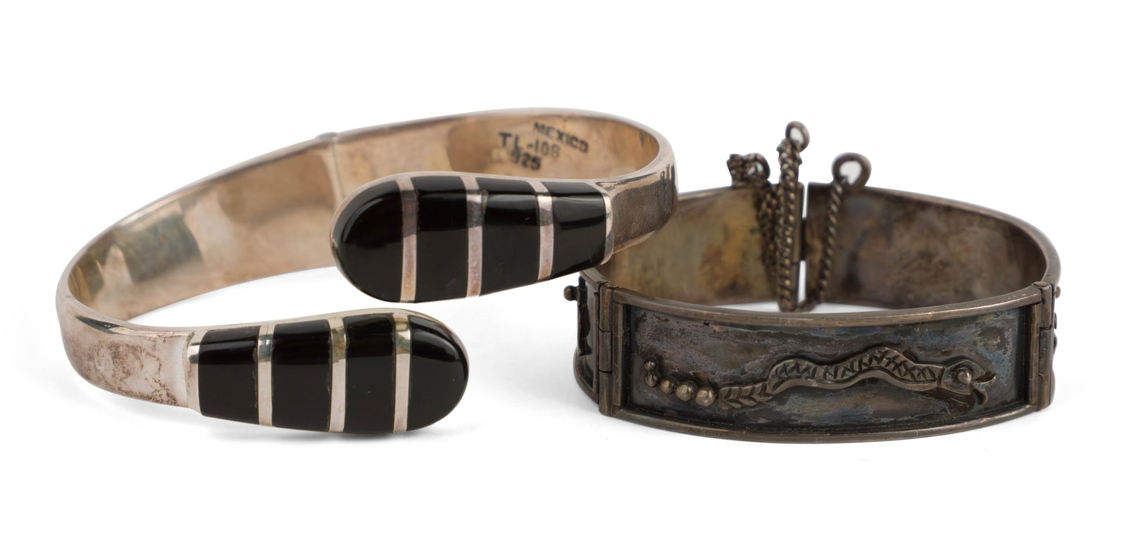 Two Mexican Silver Bracelets: Two Mexican Silver Bracelets The first, a 1980s silver and onyx "clamper" bracelet, marked "TL-105" "Mexico" and "925". The second a small tri-part ladies bracelet with applied Aztec motifs