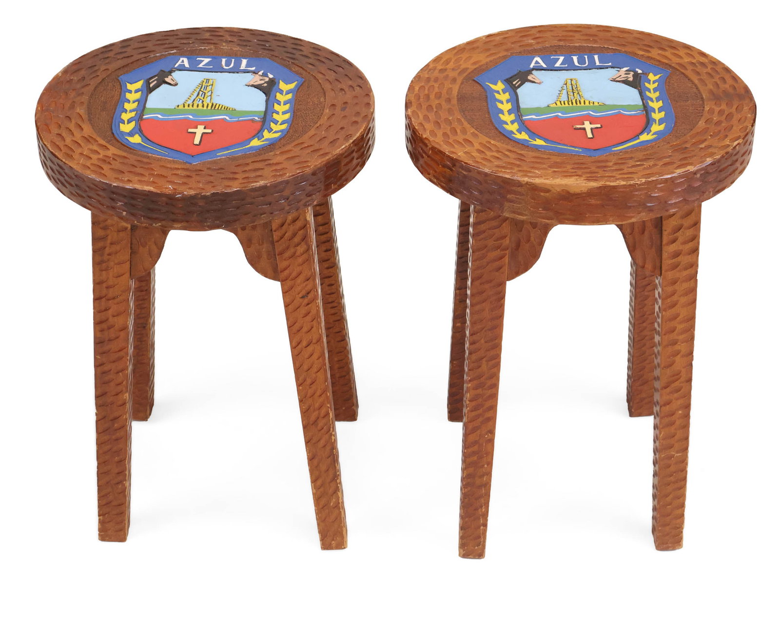Pair of Stools with the City Crest of Azul, Argentina: Pair of Stools with the City Crest of Azul, Argentina Hand-carved wooden stools, featuring the coat of arms for the Azul District in Buenos Aires Province. 18 3/4 x 13 in. (47.6 x 33 cm.)