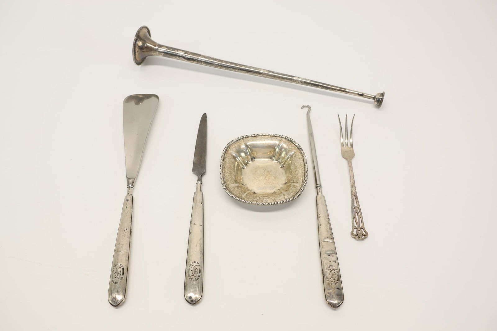Group of Assorted Sterling Silver Articles: Group of Assorted Sterling Silver Articles Comprising a sterling silver candle snuffle, Whiting nut dish, lemon fork, and a sterling silver handled file, shoe horn, and button hook. Used condition,